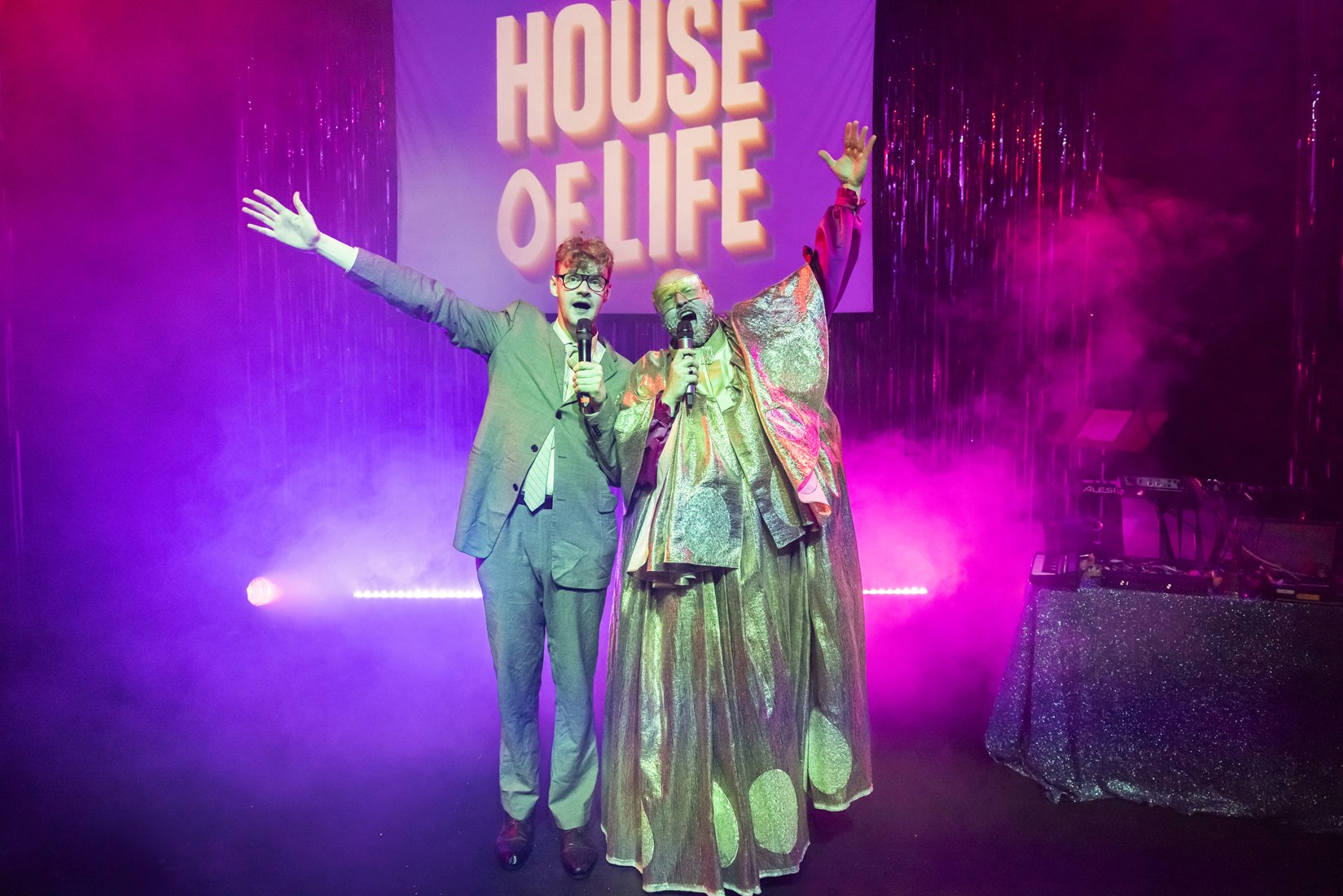House of Life backdrop with a man in a suit and a clown