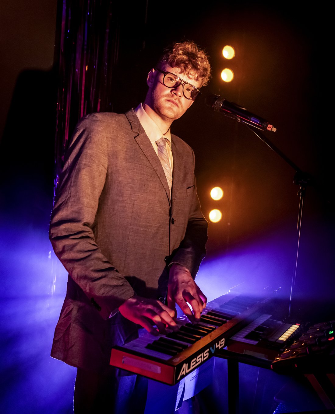 a man in a suit playing a keyboard