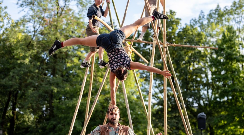 An acrobat balancing on a mans head