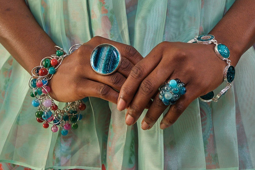 This image is a close-up photograph focused on a person's hands and jewelry, with the rest of the body mostly out of frame