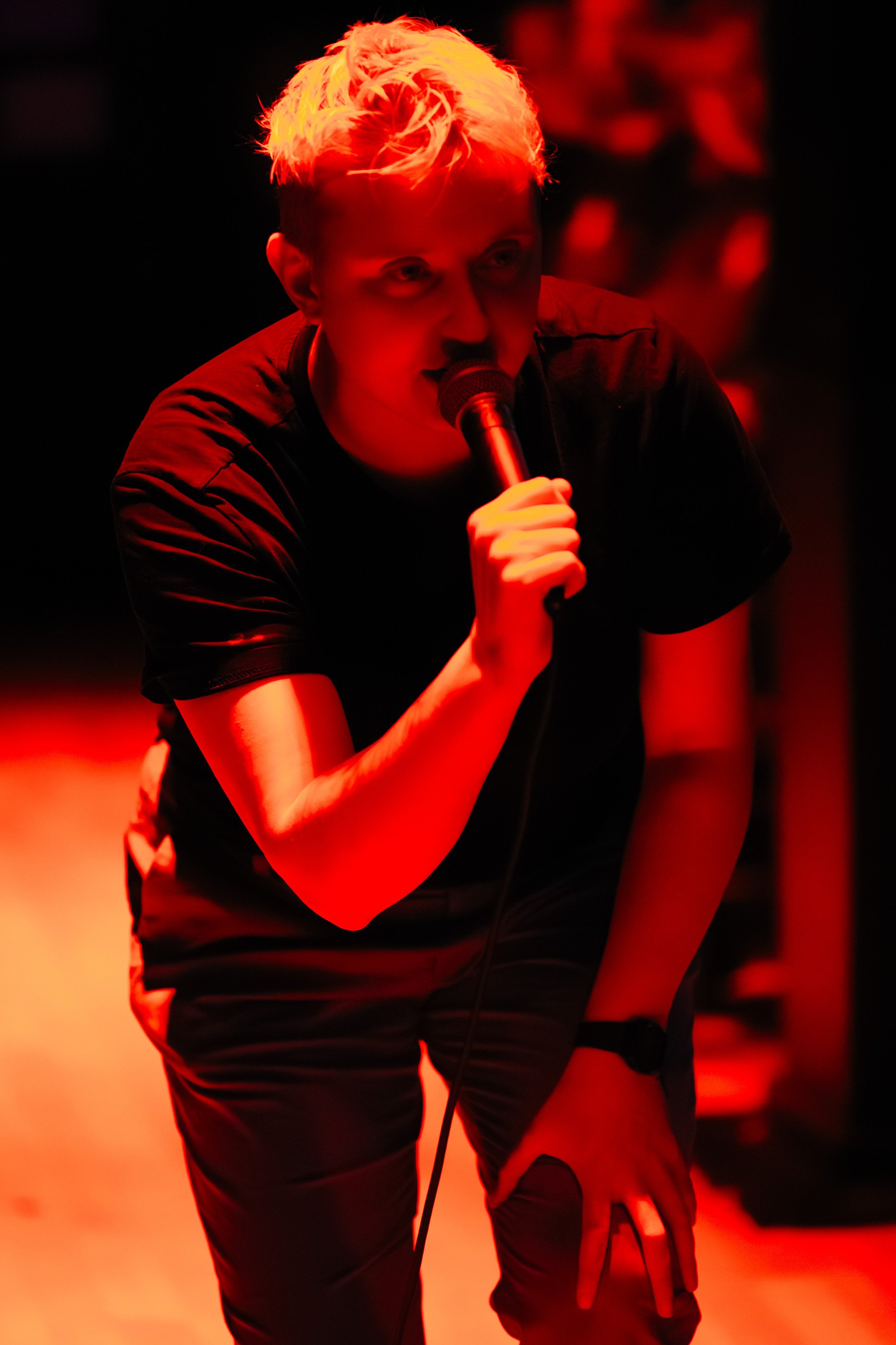 a person lit by a red light with a microphone