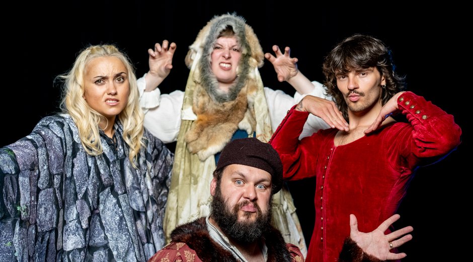 Four actors all posing on stage in a whimsical manner