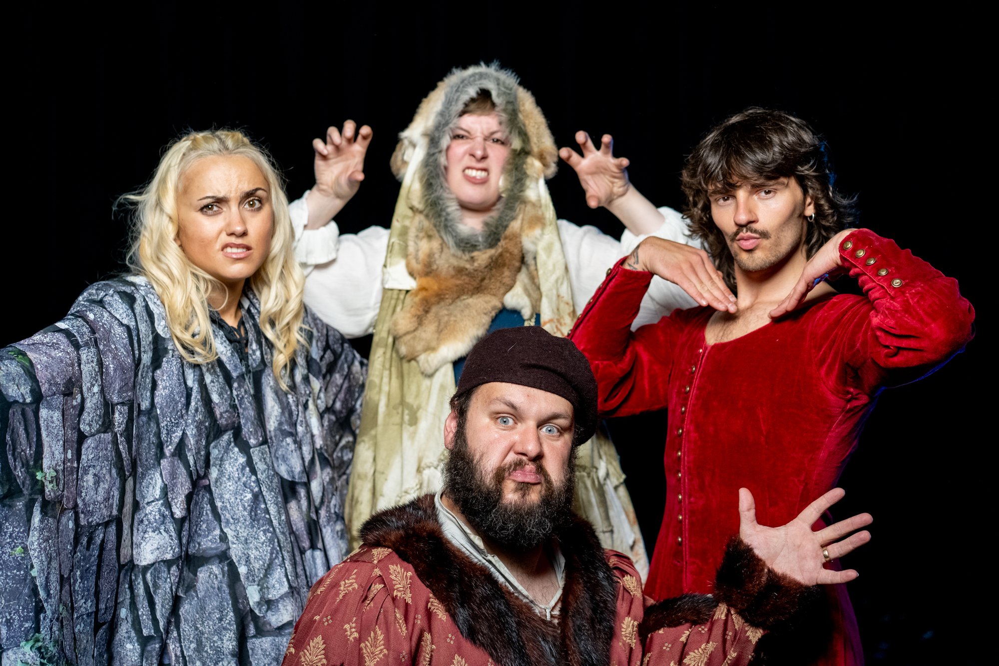 Four actors all posing on stage in a whimsical manner