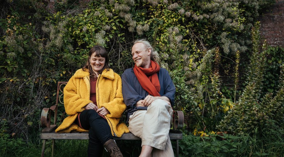 Hannah and James sat on a bench in a garden