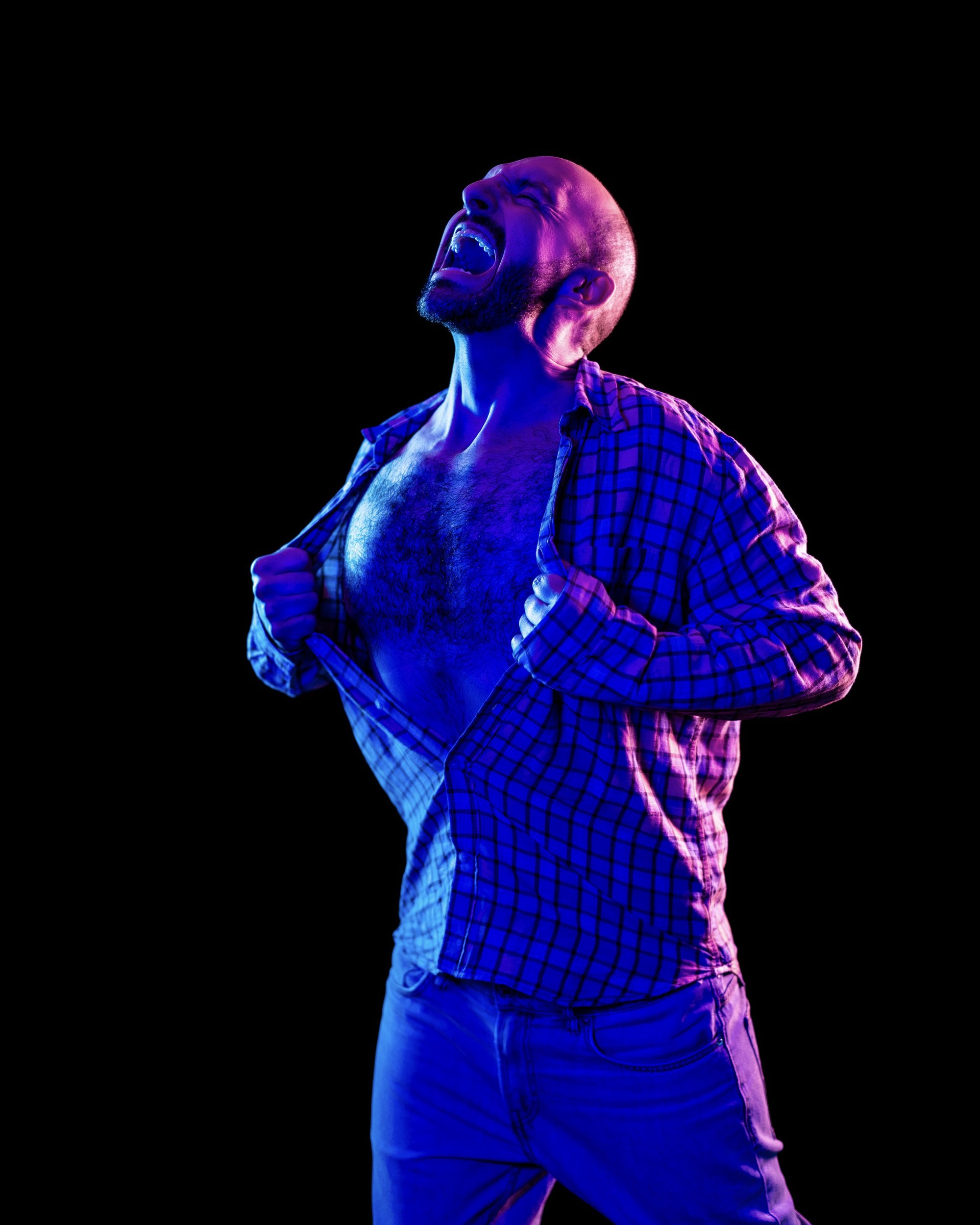 a man tearing his shirt open
