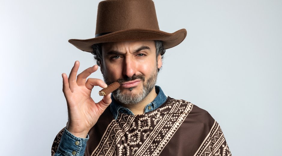 Patrick dressed as a cowboy holding a cigar