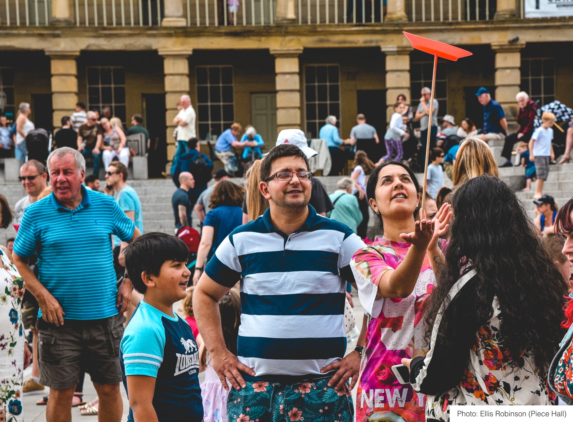 A man watching a child spin a plate
