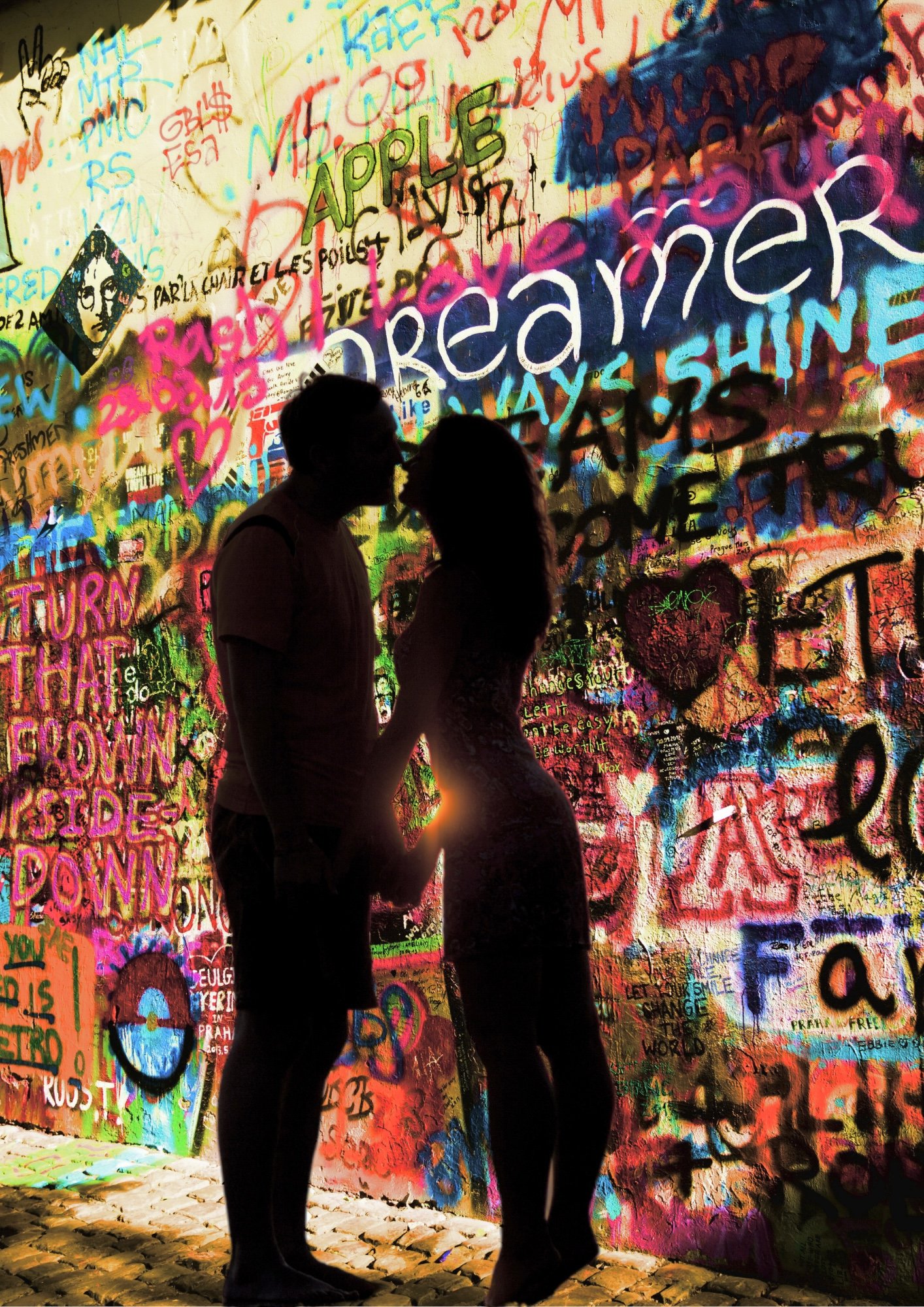 Romeo and Juliet stand in front of a wall of graffiti