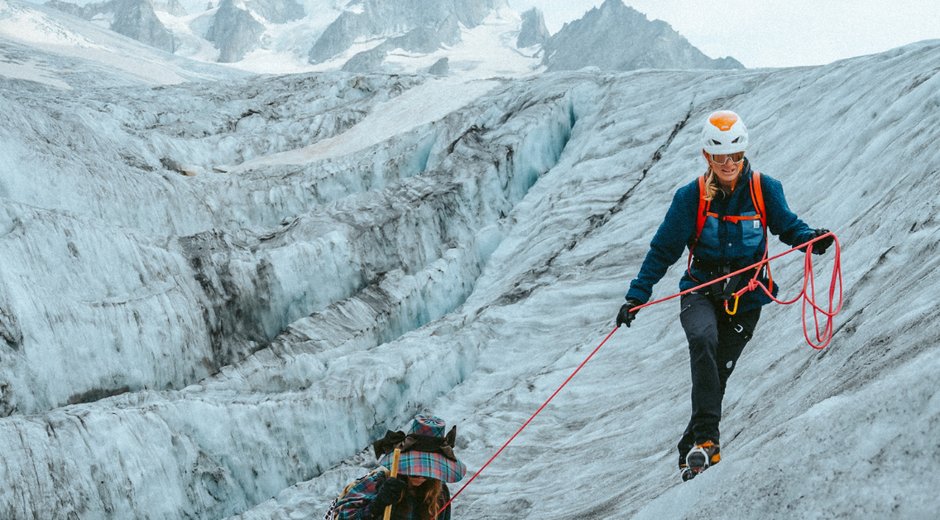 2 people climbing a glacier