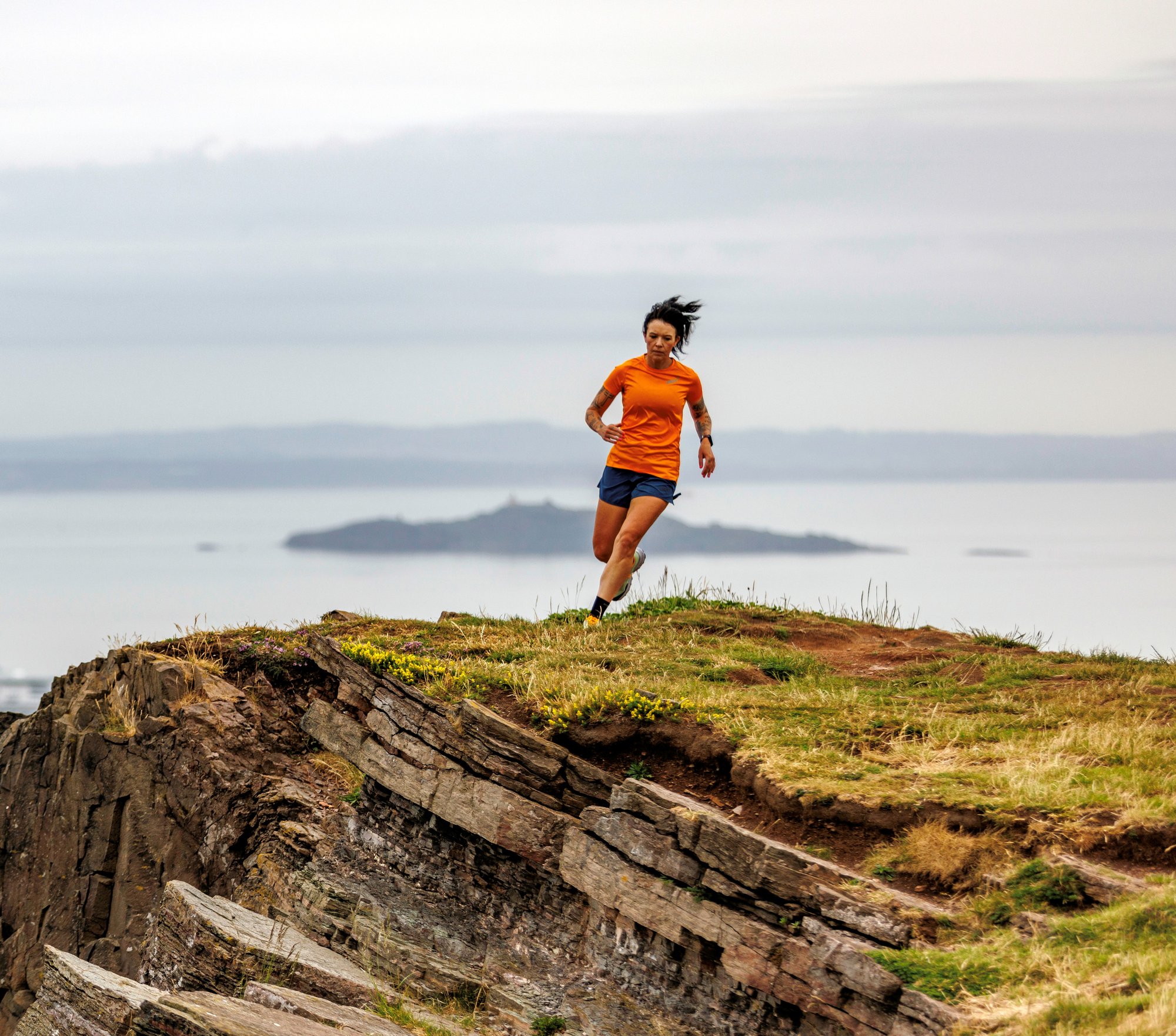 Allie Bailey running along a cliff edge