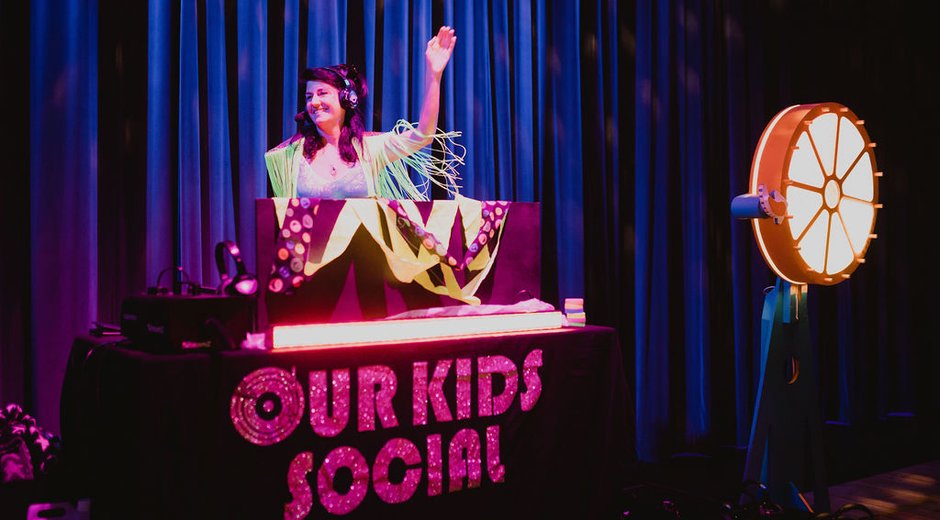 A DJ booth with the words Our Kids Social on it.