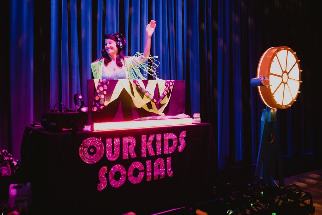 A DJ booth with the words Our Kids Social on it.