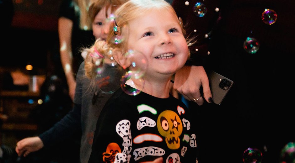 Child in halloween costume with bubbles