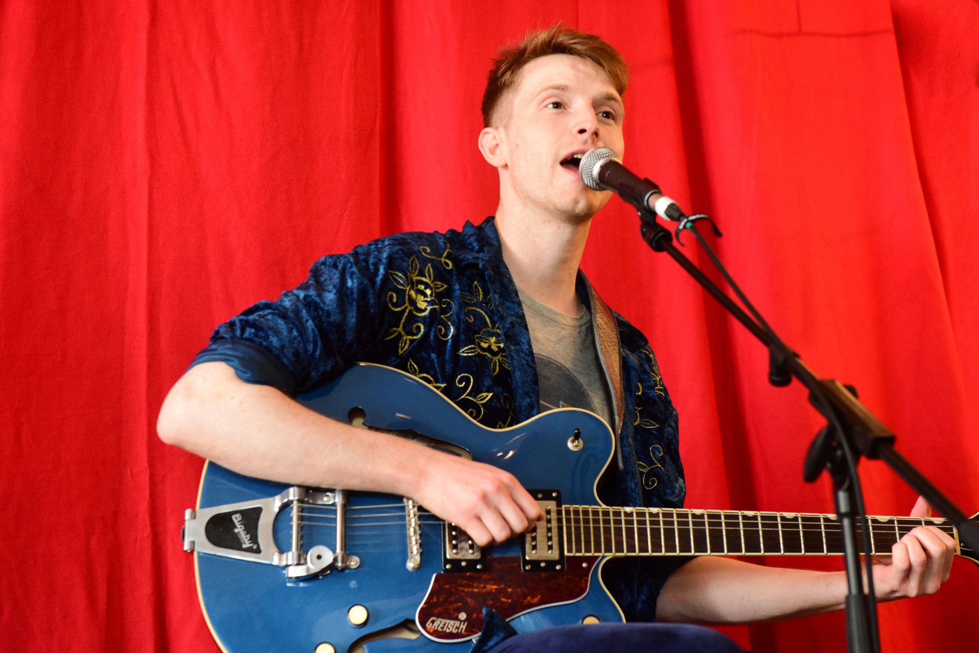 Man singing with blue guitar